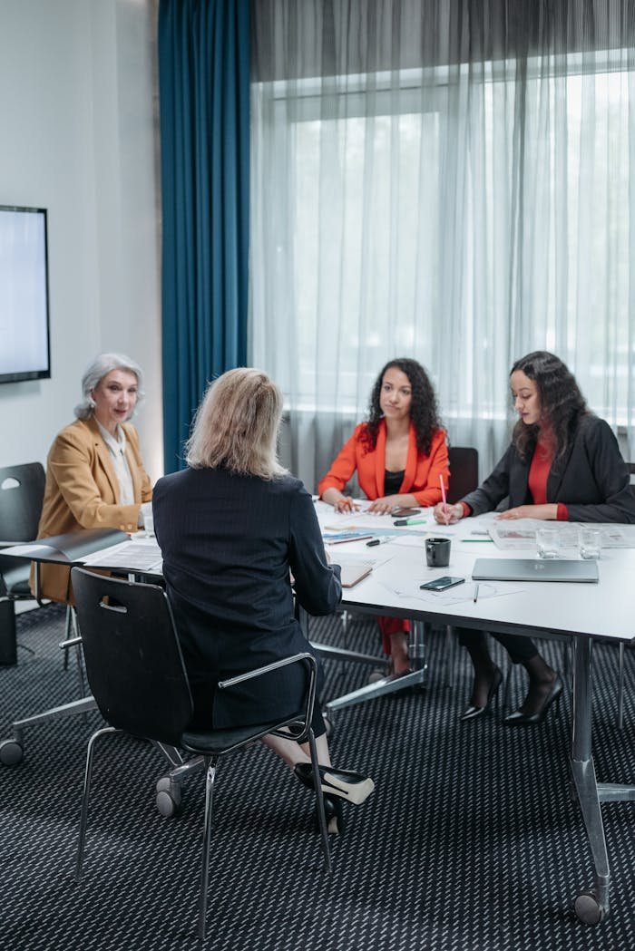 A group of businesswomen discussing strategies in a modern office setting.